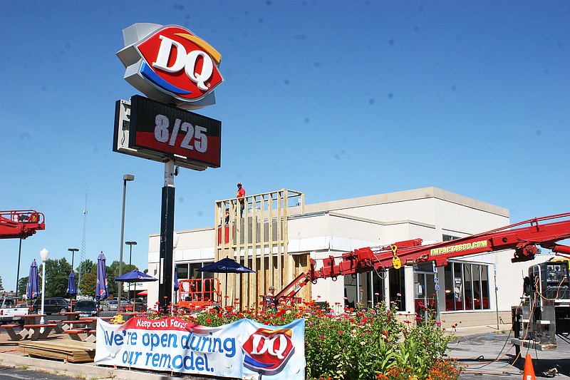 Glove Con employees work on remodeling the Dairy Queen on Business 54 to keep the store up to date with its contract. They just installed a new electronic reader board and are working to build a stone-wall chimney on the patio. The remodel is expected to be complete by the end of October.