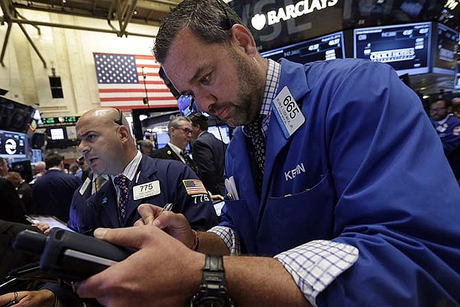 Traders Fred DeMarco, left, and Kevin Lodewick, right, work on the floor of the New York Stock Exchange, Tuesday, Aug. 25, 2015. U.S. stocks jumped at the open after China's central bank cut interest rates to support its economy.