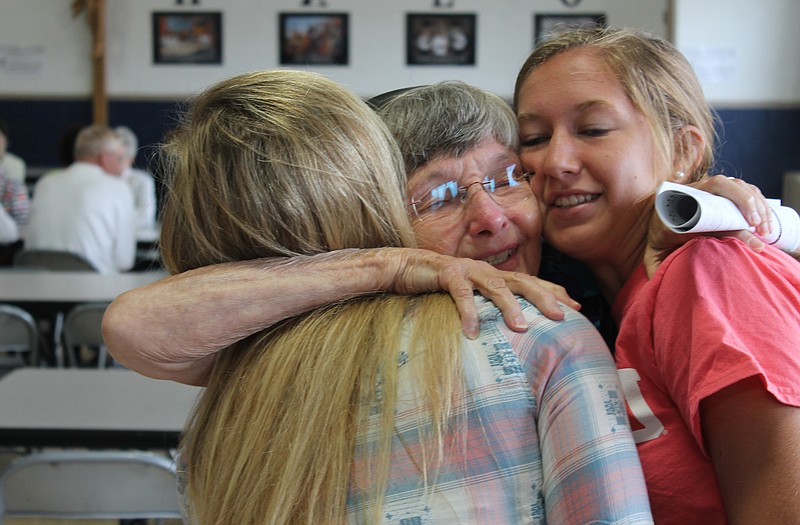Sister Josetta Eveler hugs Immaculate Conception School student Kayla Yanskey, right, and an unidentified student during her Sunday retirement reception.
