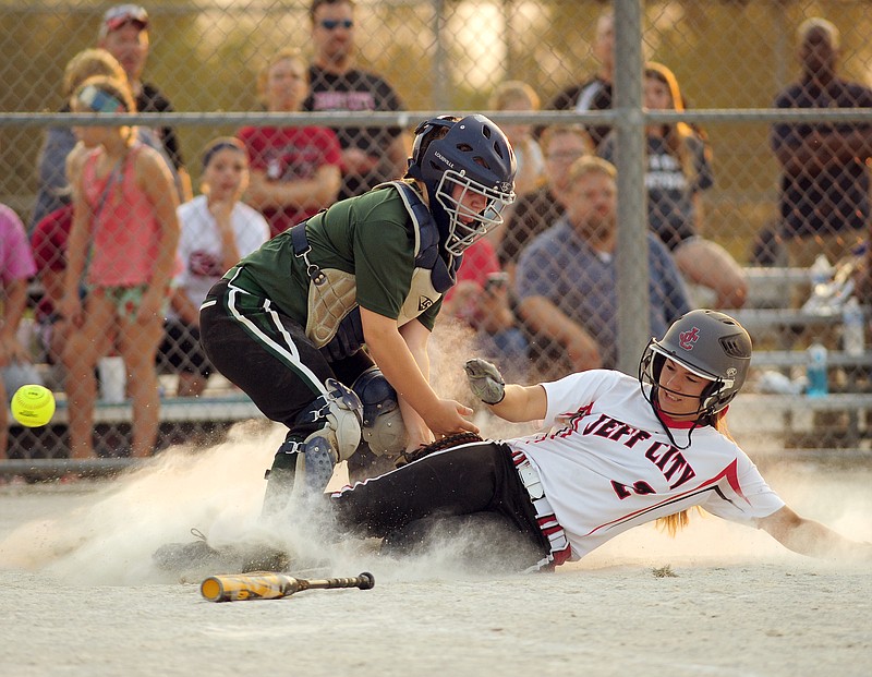 Jefferson City's Taylor Dey slides safely into home and knocks the ball away from Rock Bridge catcher Charlessa Elliott in the bottom of the first inning of the Lady Jays' home opener at 63 Diamonds on Wednesday.