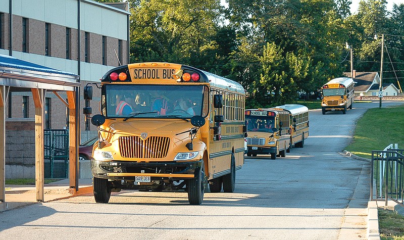 Another school bus enters the driveway to join the buses already at the student drop off area at the California elementary and middle schools on the first day of school, Thursday, Aug.20.