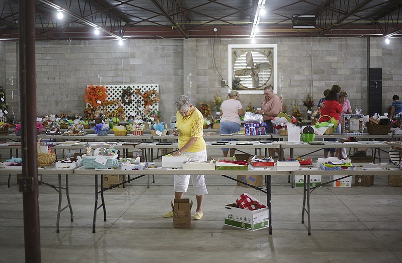 Participants browse items on Thursday, Aug. 27, 2015 during the silent auction portion of the annual Boost Barbecue at the Jaycees Fairgrounds. Proceeds from the barbecue and auction support the Boost nutritional program and wigs for cancer patients.