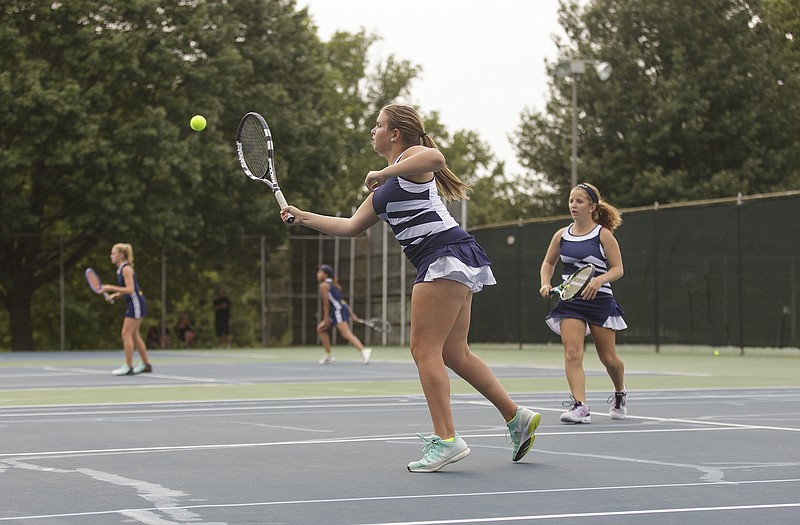 Helias' Megan Oliver hits a return during the doubles action Thursday with Battle at Washington Park.