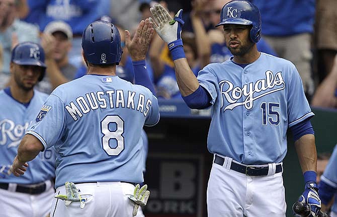 Kansas City Royals' Mike Moustakas (8) is congratulated by on-deck batter Alex Rios (15) after scoring on a single by teammate Salvador Perez during the fourth inning of a baseball game against the Baltimore Orioles at Kauffman Stadium in Kansas City, Mo., Thursday, Aug. 27, 2015.