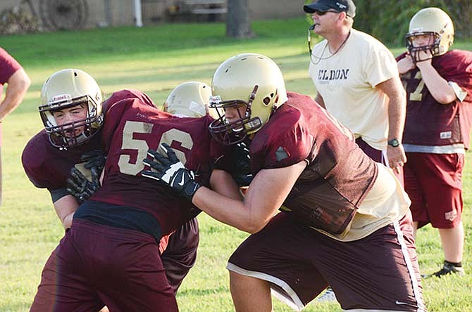 Eldon's Dalton Delong (56) is double teamed by Sammy Vladeff (right) and Cole Walker during practice earlier this
month.