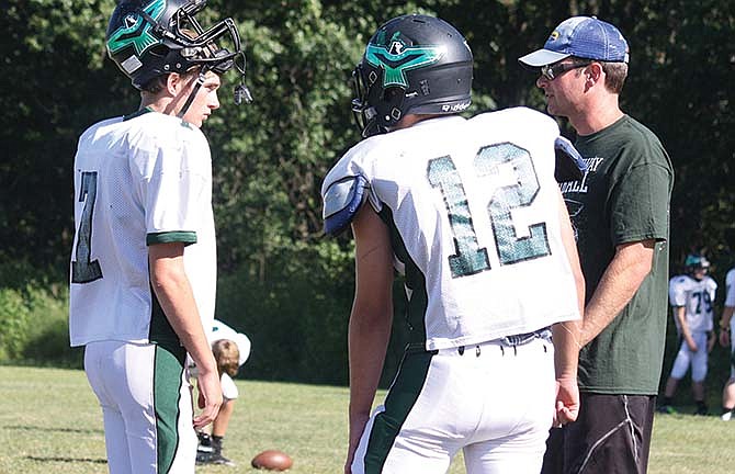 North Callaway junior quarterback Milo Henry (left) talks with offensive coordinator Reid Randolph during practice
this week.