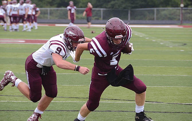 Dylan Brown (5) breaks away from a tackle attempt by Russell Williams (9) during a School of the Osage scrimmage earlier this month.