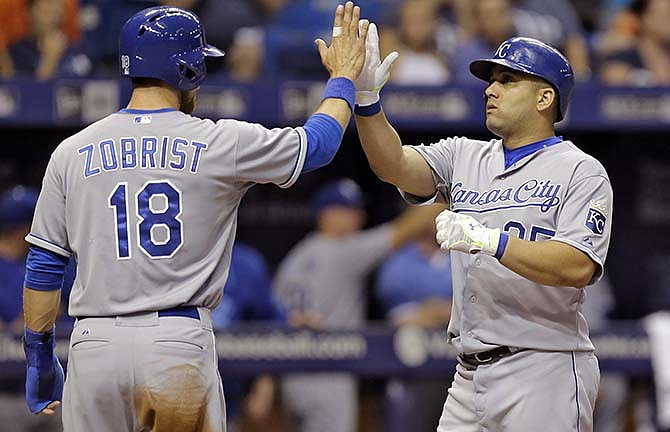 Kansas City Royals' Kendrys Morales, right, high-fives Ben Zobrist after hitting a two-run home run off Tampa Bay Rays starting pitcher Erasmo Ramirez during the third inning of a baseball game Friday, Aug. 28, 2015, in St. Petersburg, Fla.