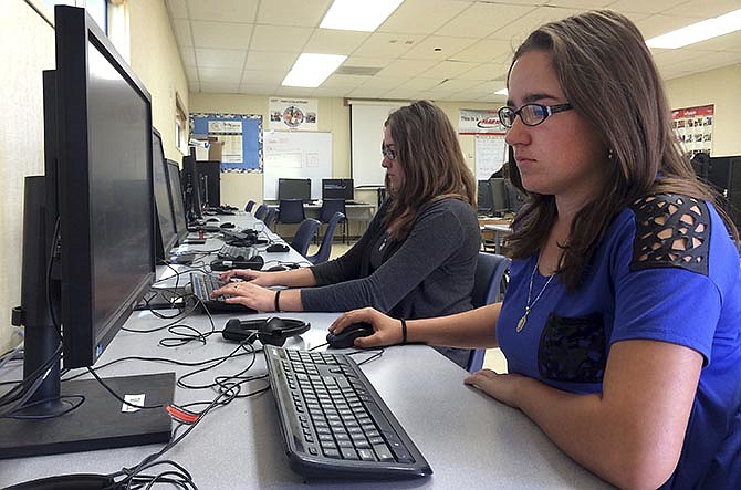 In this April 30, 2015 file photo, Leticia Fonseca, 16, left, and her twin sister, Sylvia Fonseca, right, work in the computer lab at Cuyama Valley High School after taking the new Common Core-aligned standardized tests, in New Cuyama, Calif. Test results for this year's Common Core-aligned exams are starting to be released, and while several states report higher-than-expected scores, vast numbers of students didn't test proficient in math or reading.
