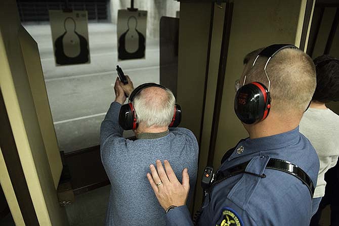 In this Oct. 29, 2013 file photo, Martin Beck, a participant in the Missouri State Highway Patrol's Community Alliance Program, fires a trooper's Glock 22 pistol during a shooting exercise at the Patrol's gun range. Participants in the program are taught basic gun safety, as well as proper grip and stance for firing the weapons. 