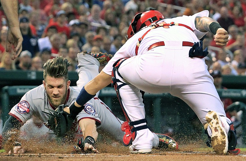 Bryce Harper of the Nationals scores ahead of the tag of Cardinals catcher Yadier Molina during the first inning of Monday night's game at Busch Stadium.