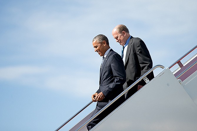 President Barack Obama, accompanied by Alaska Gov. Bill Walker, steps off Air Force One after arriving Monday at Elmendorf Air Force Base in Anchorage, Alaska. Obama opens a historic three-day trip to Alaska aimed at showing solidarity with a state often overlooked by Washington, while using its glorious but changing landscape as an urgent call to action on climate change.