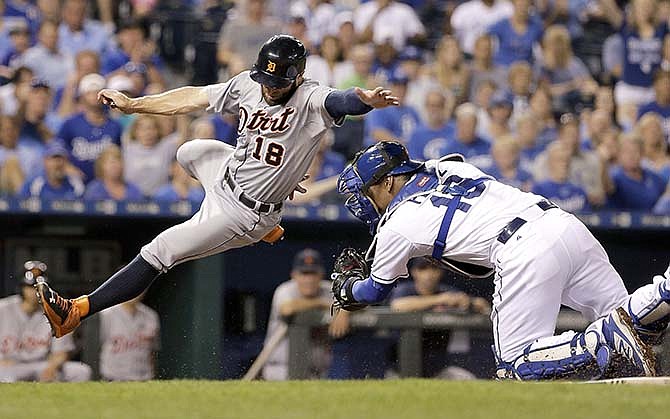 Detroit Tigers' Tyler Collins is forced out at home by Kansas City Royals catcher Salvador Perez as he tried to score on a fielders choice hit into by Jose Iglesias during the fourth inning of a baseball game Tuesday, Sept. 1, 2015, in Kansas City, Mo. 