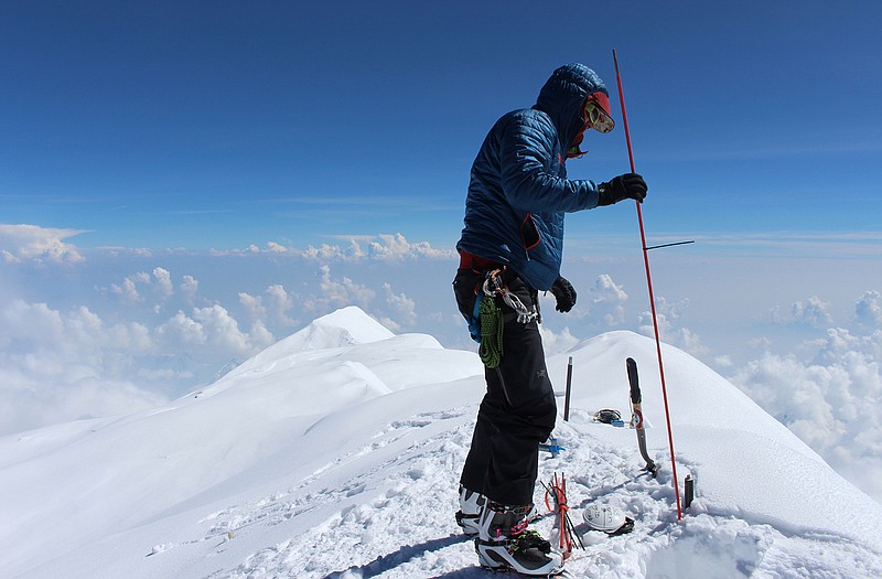 Blaine Horner of CompassData probes the snow pack at the highest point in North America along with setting up Global Position System equipment for precise summit elevation data on top of Denali in Denali National Park, Alaska. 
