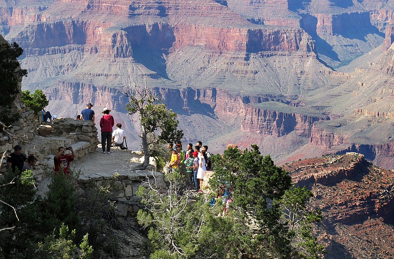 Visitors gather at an outlook on the South Rim of Grand Canyon National Park in northern Arizona. The Grand Canyon and other big national parks are seeing more visitors than usual this year, partly driven by good weather, cheap gas and marketing campaigns. 