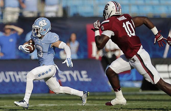 North Carolina's Ryan Switzer (3) runs past South Carolina's Skai Moore (10) in the first half of an NCAA college football game in Charlotte, N.C., Thursday, Sept. 3, 2015.