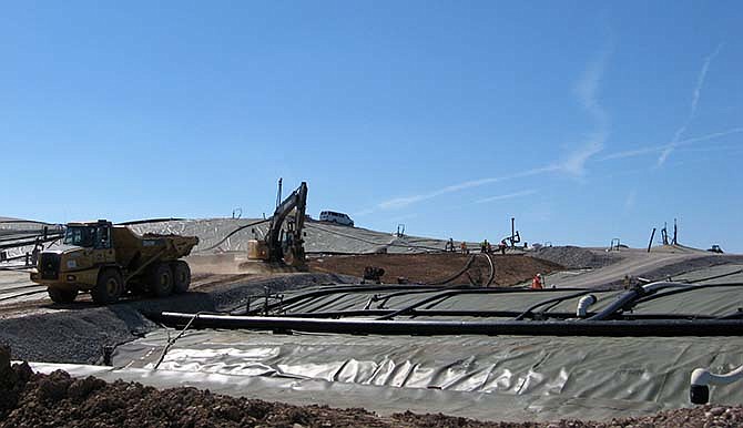 In this Aug. 13, 2014 photo, a dump truck and backhoe put fill dirt into the Bridgeton Landfill in Bridgeton, Mo. Missouri Attorney General Chris Koster released new reports Thursday, Sept. 3, 2015, he says raise troubling concerns about the environmental fallout from contamination and a subsurface fire at a landfill. (AP Photo/St. Louis Post-Dispatch, Jacob Barker, File)