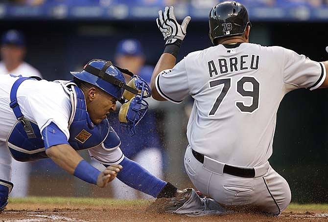Chicago White Sox' Jose Abreu (79) beats the tag by Kansas City Royals catcher Salvador Perez during the first inning of a baseball game at Kauffman Stadium in Kansas City, Mo., Friday, Sept. 4, 2015. Abreu scored on a hit by teammate Avisail Garcia.
