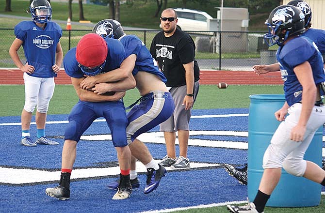 
South Callaway defensive players
work on a tackling drill while head
coach Zack Hess - who also serves
as defensive coordinator - watches
in the background during Tuesday's
practice.