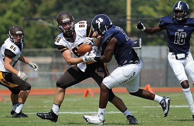 Lincoln linebacker Treston Pulley and Quincy tight end Owen
Schoenenberger battle for possession of the ball last season.