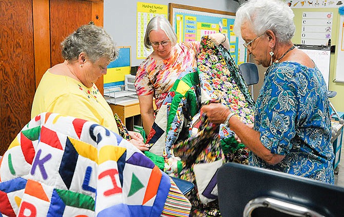 Rita Harris, left, entered her mother's embroidered quilt, which won first place, in Saturday's High Point Homecoming quilt show, organized by Juanita Golden, center. Shirley Patton, right, also won first place in the applique division.