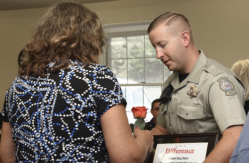 Cole County Sheriff Deputy Kyle Petty receives a rose from Patricia Tufts to express her gratitude for his attempts to keep drunk and impaired drivers off the streets and highways. Tufts' son, Michael, died last year of injuries from a wreck caused by a drunk driver in December 2012.