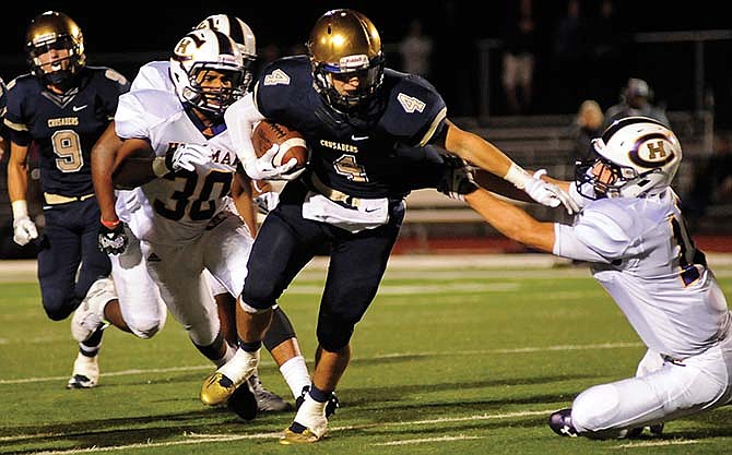 Helias' Nolan Sachse stiff arms Hickman's Andrew Paten as he picks up extra yardage on a punt return during Saturday's game at Adkins Stadium in Jefferson City.