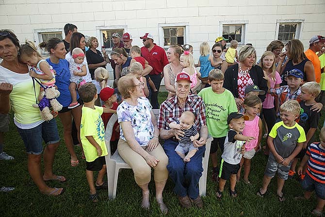Leonard and Rosemary Kempker, center, attempt to pose for photos with members of their family
at their home near Eugene in August during a birthday celebration for Leonard. After having 12
children of their own, the Kempkers have about 120 grandchildren, with more on the way.