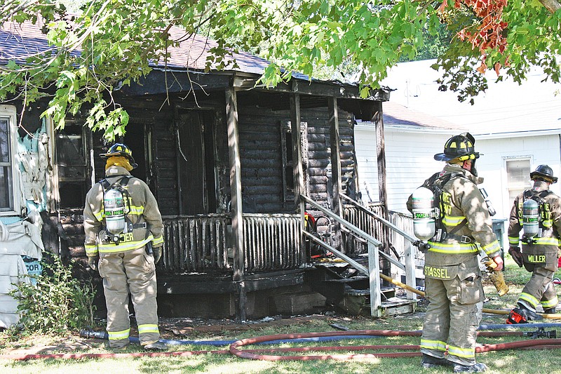 Members of the Fulton Fire Department work to secure a house following an extensive house fire. There were five occupants in the house when the fire started, but were able to leave without injuries.