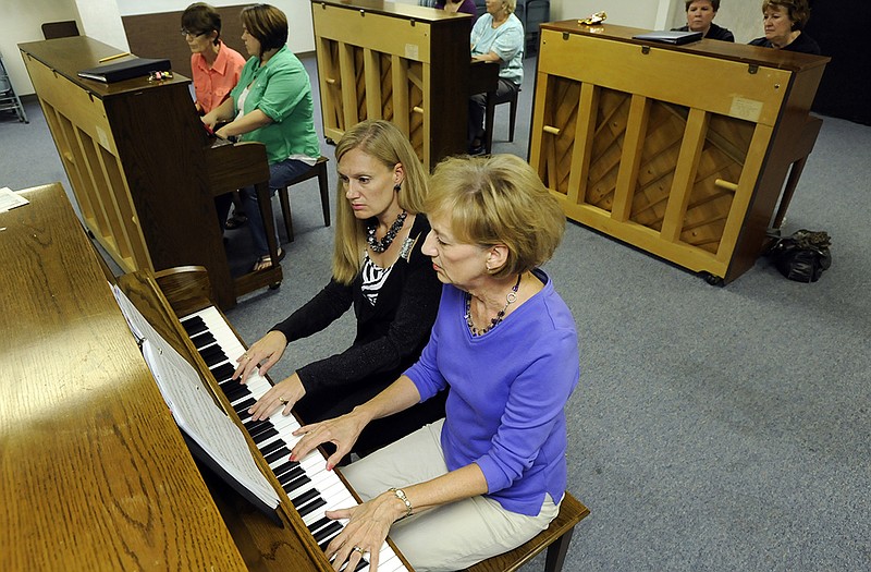 Martha Jobe, front right, and daughter Denise Gillam share piano space as they and other pianists play together while rehearsing for the upcoming Piano Praise 2015 event at First Baptist Church.
