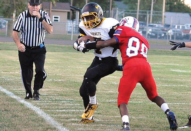 Fulton wide receiver Makygh Galbreath tries to free himself from the grasp of a Moberly defender during the Hornets' 35-6 win against the Spartans in a football game Friday, Sept. 16, 2016 in Moberly.