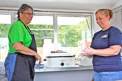 Volunteer Pam Heimericks (left) and CMCA volunteer Teressa Huskey help prepare food in a food truck Friday afternoon at the Callaway County United Way Radiothon and Campaign Kickoff. Heimericks sold homemade slices of pie baked by Callaway 4-H team leaders and Huskey helped sell food such as hot dogs and hamburgers.