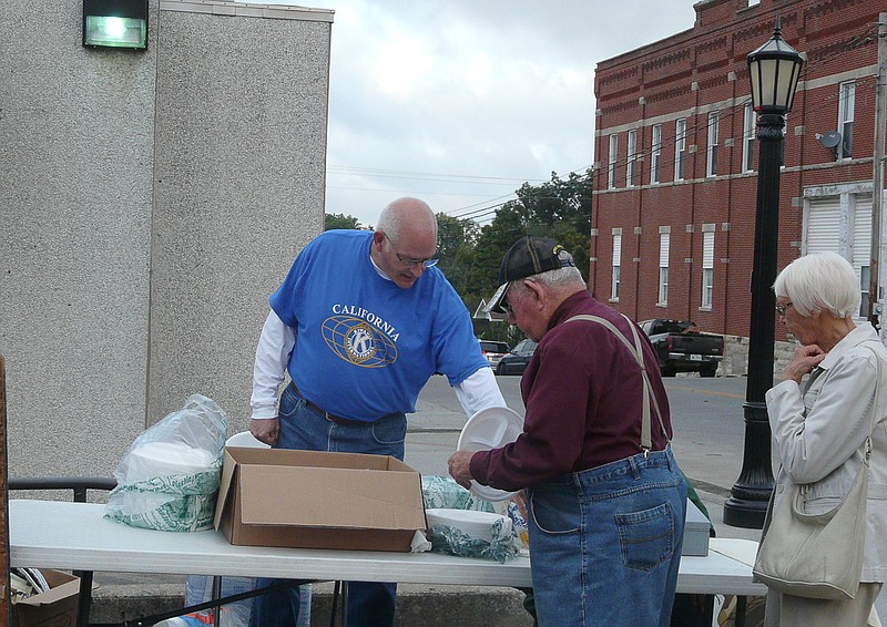 Kiwanis member Bobby Roll assist patrons as they attend the Kiwanis Breakfast at the Ozark Ham and Turkey Festival.