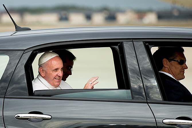 Pope Francis waves from a Fiat 500L as his motorcade departs Andrews Air Force Base, Md., Tuesday, Sept. 22, 2015, after being greeted by President Barack Obama and first lady Michelle Obama.