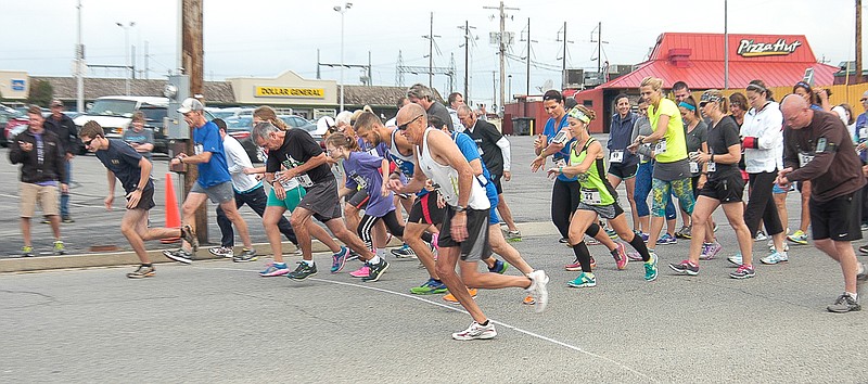 The runners begin their 5-kilometer trek through the residential streets south of Village Green Shopping Center on Saturday, Sept. 19. The Walk / Run event begins the day-long Ozark Ham and Turkey Festival.