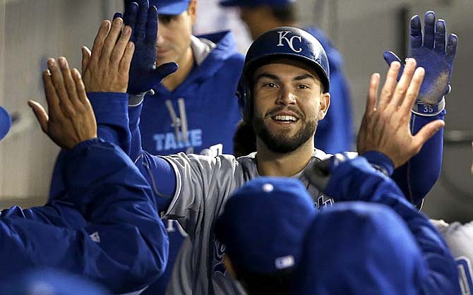 Kansas City Royals' Eric Hosmer celebrates in the dugout after scoring on a home run by Mike Moustakas, off a pitch from Chicago White Sox starting pitcher John Danks, during the third inning of a baseball game Thursday, Oct. 1, 2015, in Chicago.