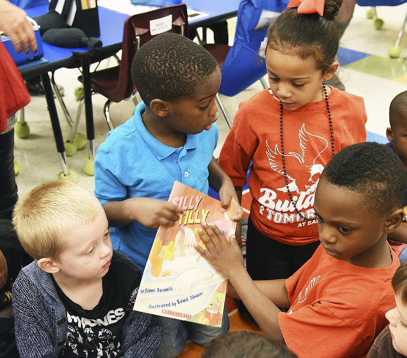 Students in Angela Adams' kindergarten class at East School feel the braille text on the book read to them Friday by Rita Lynch. The students, clockwise from left are Brooks Dinolfo, James Criddle, Lanaia Newsome and Deontae Ingram.