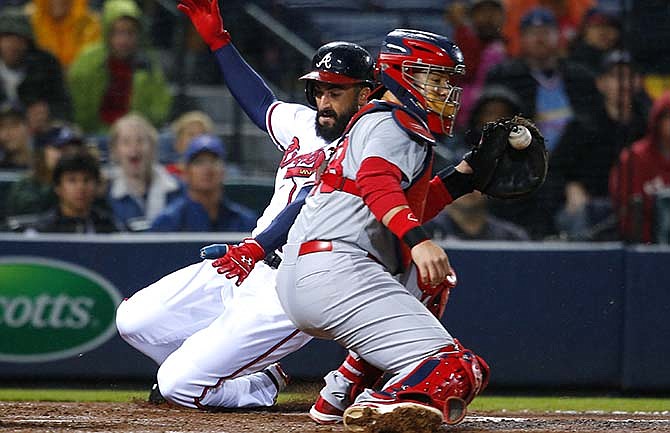 Atlanta Braves Nick Markakis slides in under the tag of St. Louis Cardinals catcher Tony Cruz (48) to score off the double of A.J. Pierzynski in the third inning of a baseball game against the St. Louis Cardinals, Friday, Oct. 2, 2015, in Atlanta.