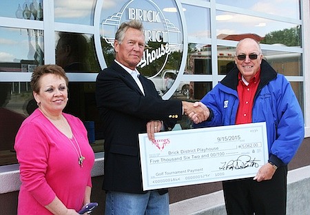 Mayor LeRoy Benton presents John Bell and Gayla Dunn with a check for the new Brick District Playhouse Friday. The check, which was written out for $5,062, was the generated from the annual Mayor's Cup golf tournament. The plan is to use the playhouse as a venue for concerts, comedy acts and theatrical productions. A cafeÌ will open in front at the beginning of October.