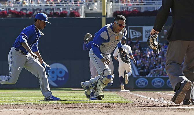 Kansas City Royals catcher Salvador Perez, center, and pitcher Yordano Ventura, left, watch as a bunt by Minnesota Twins' Eddie Rosario goes foul in the fifth inning of a baseball game, Saturday, Oct. 3, 2015, in Minneapolis.
