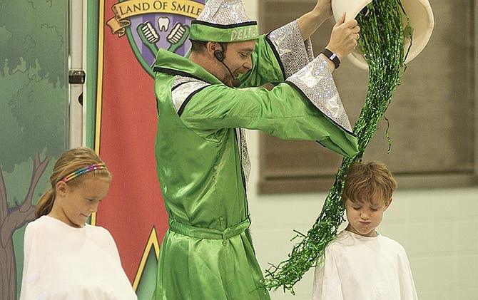 
A Fatima Elementary student holds
his breath as the Tooth Wizard runs
streamers representing mouthwash
over him on Wednesday during Delta
Dental's presentation on oral care to
more than 100 students.