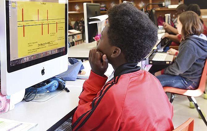 DeVonte' Lowery works on a class project in Aaron DeSha's fifth-grade room in Jefferson City. Students use computers and the smart board to
learn the subject matter. Missouri schools saw mixed results from the new MAP test and area districts are looking into ways
to improve student performance.