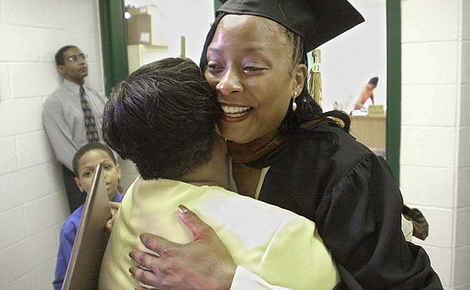  In this Friday, May 11, 2001 photo, new college graduate Paula Cooper is congratulated by her sister, Rhonda LaBroi, after receiving a bachelor's degree from Martin University during a graduation ceremony for her and 16 other inmates at the Indiana Women's Prison in Indianapolis. (Matt Detrich/The Indianapolis Star via AP)