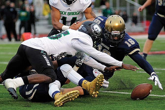 
Helias linebacker Adam Bax and Rock Bridge defensive back Raekwon Jackson scramble for a loose ball Saturday at Adkins Stadium.