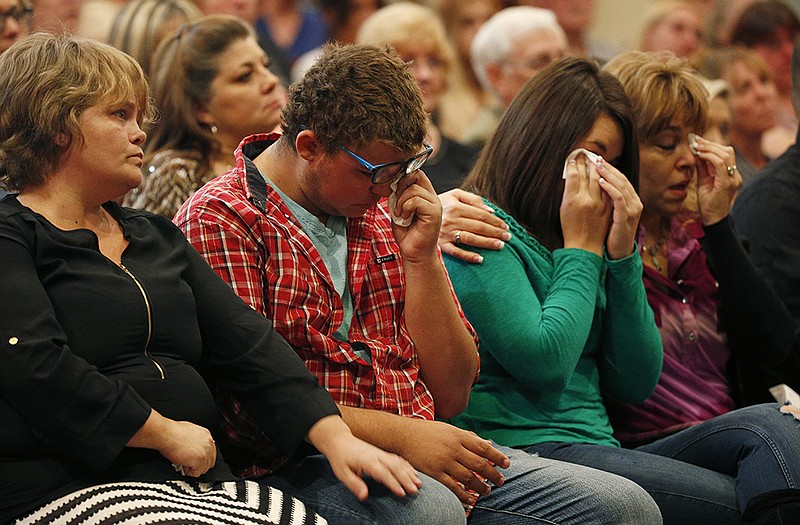 From left, Summer Smith, Mathew Downing, Lacey Scroggins and Lisa Scroggins react during a church service at the New Beginnings Church of God, Sunday in Roseburg, Ore. Mathew Downing and Lacey Scroggins are survivors of the shooting at Umpqua Community College. 