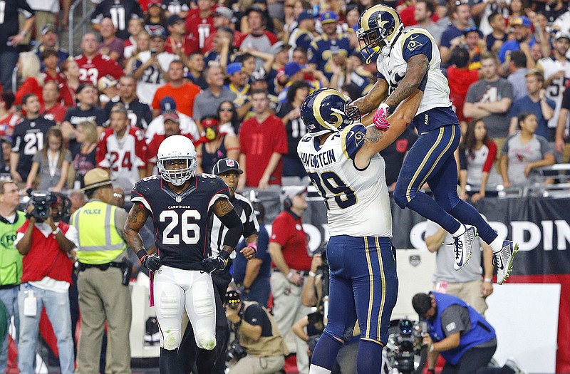 Rams offensive tackle Rob Havenstein (79) lifts Tavon Austin into the air following his second touchdown of Sunday's game in Glendale, Ariz., as dejected Cardinals free safety Rashad Johnson walks by.