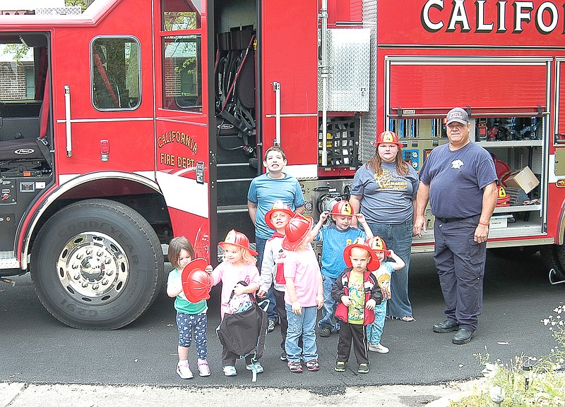 Young people at "Kids World" day care, operated by Cathy Wagner, have their photo taken with the City of California Fire Chief and a city fire engine.