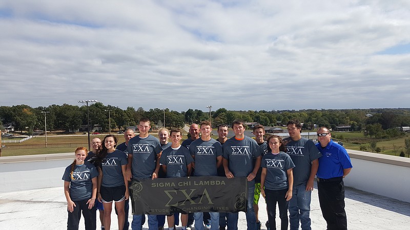 Russellville members of Sigma Chi Lambda - integrity, honesty, loyalty, respect and honor display their banner.