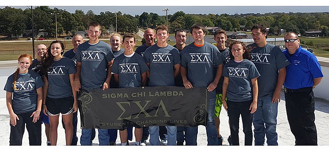 Members of Sigma Chi Lambda, Russellville's new student organization, display their banner.