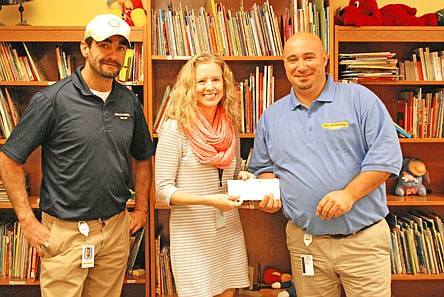 Joseph Hunter of Dollar General, Fulton Education Center Director Jen Meyerhoff and Steve Gibson of Dollar General work together to provide books for the Parents as Teachers program entitled Bee a Reader. Educators involved in the PAT program received a $4,000 grant to buy books for families.